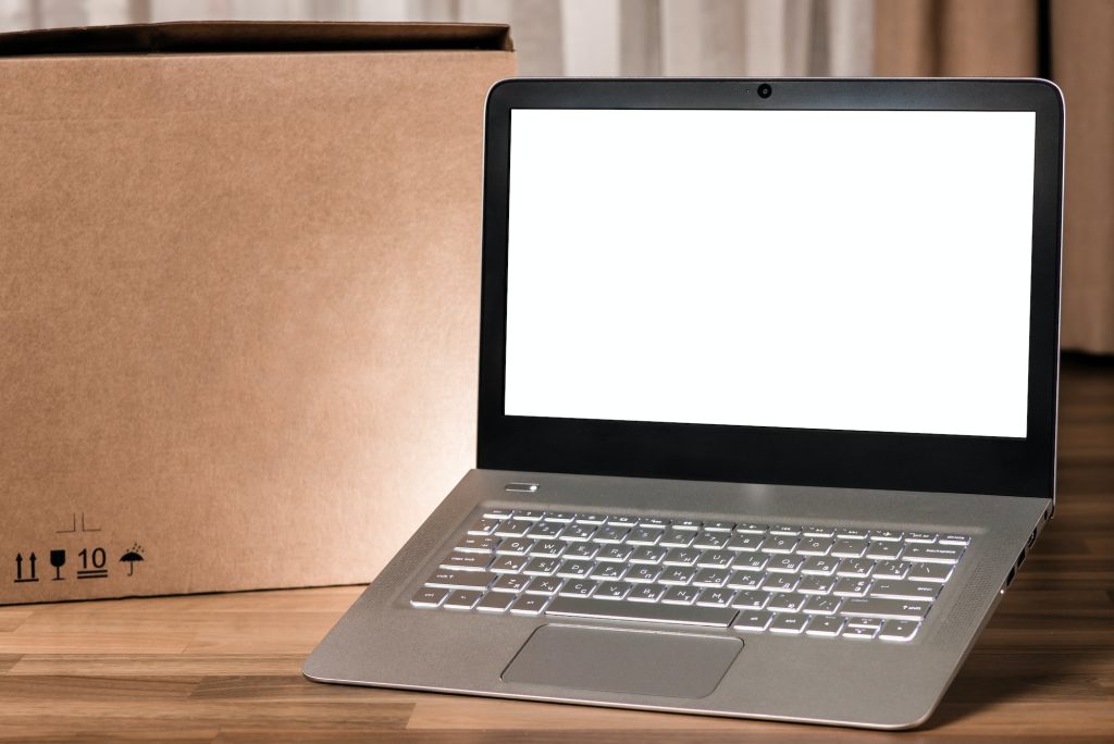 Laptop with blank screen on wooden table and blurred background