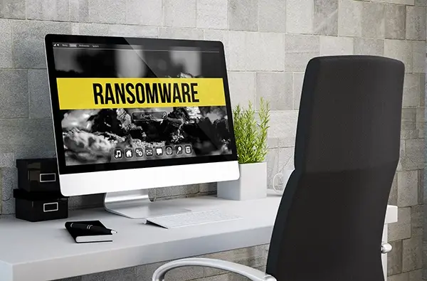 computer on desktop with the word Ransomware