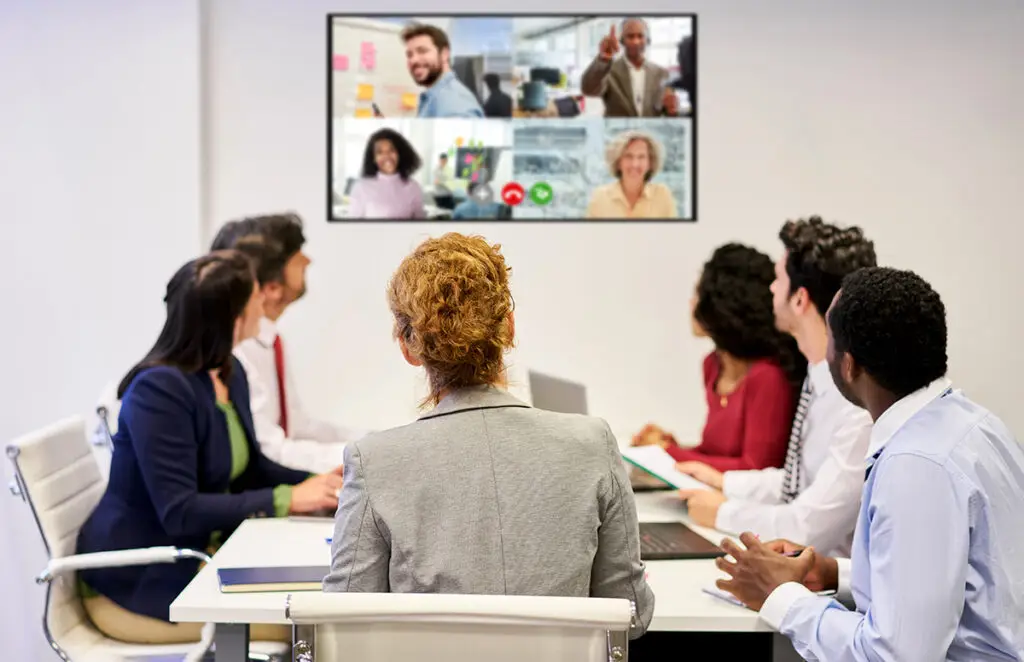 Online meeting with video conference from the business team in the conference room with colleagues connected from the home office